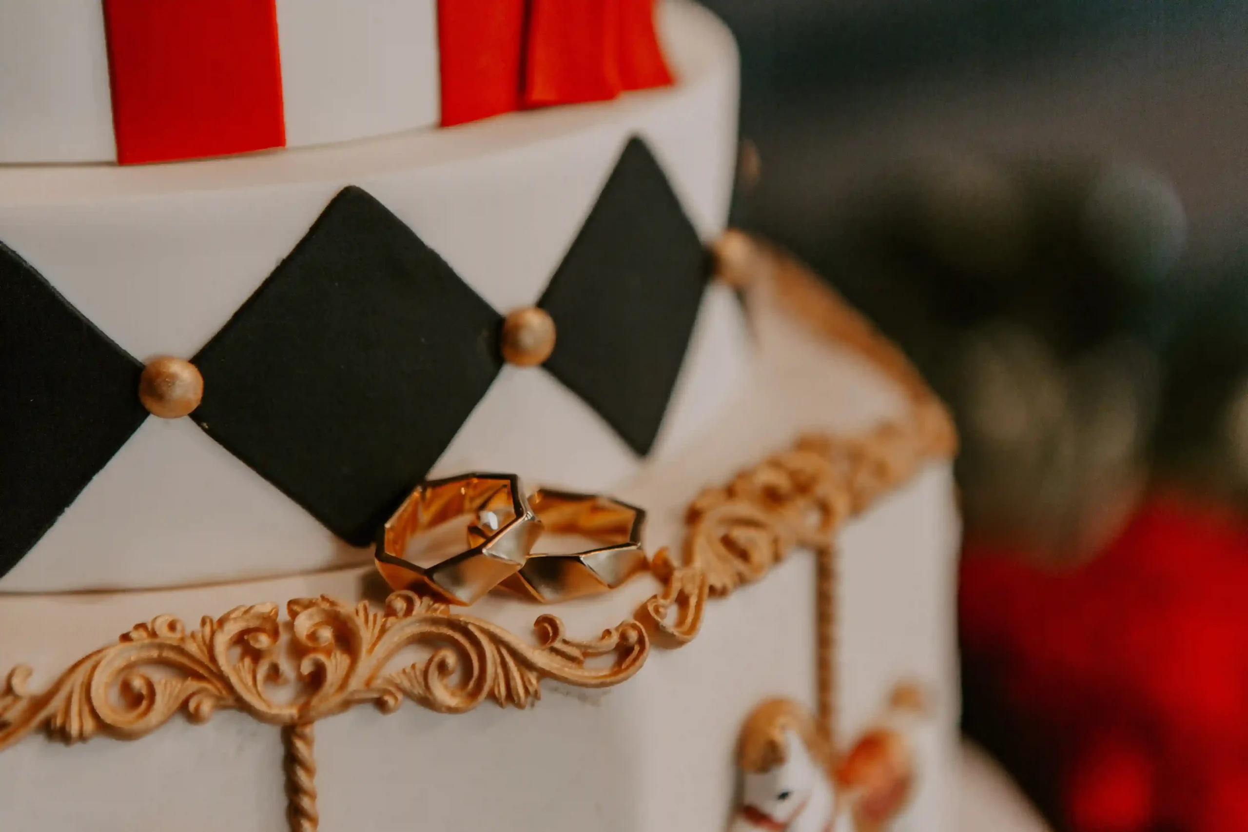 Nahaufnahme von dekoriertem Gebäck mit rot-weissen Zirkusmotiven und kleinen goldfarbenen Details.
